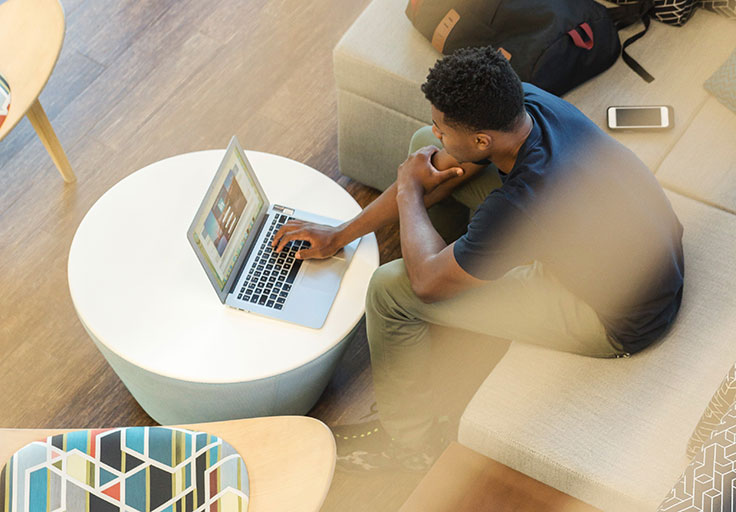 man-using-gray-laptop-while-sitting-on-beige-sofa