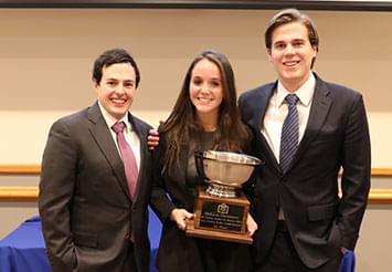 well dressed students holding trophy