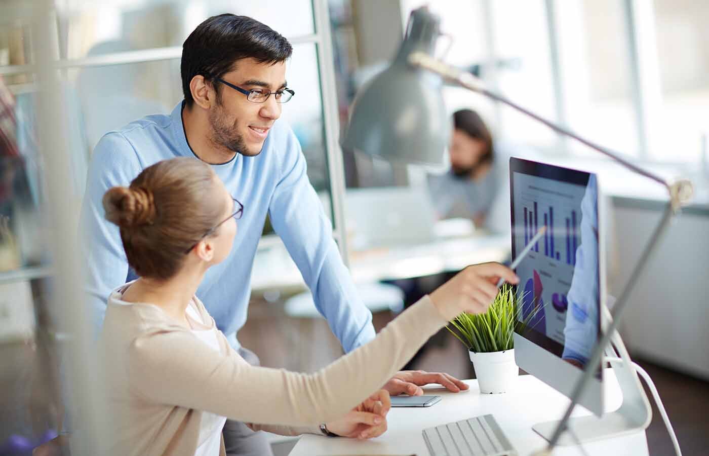 Business analysts looking at charts on a computer