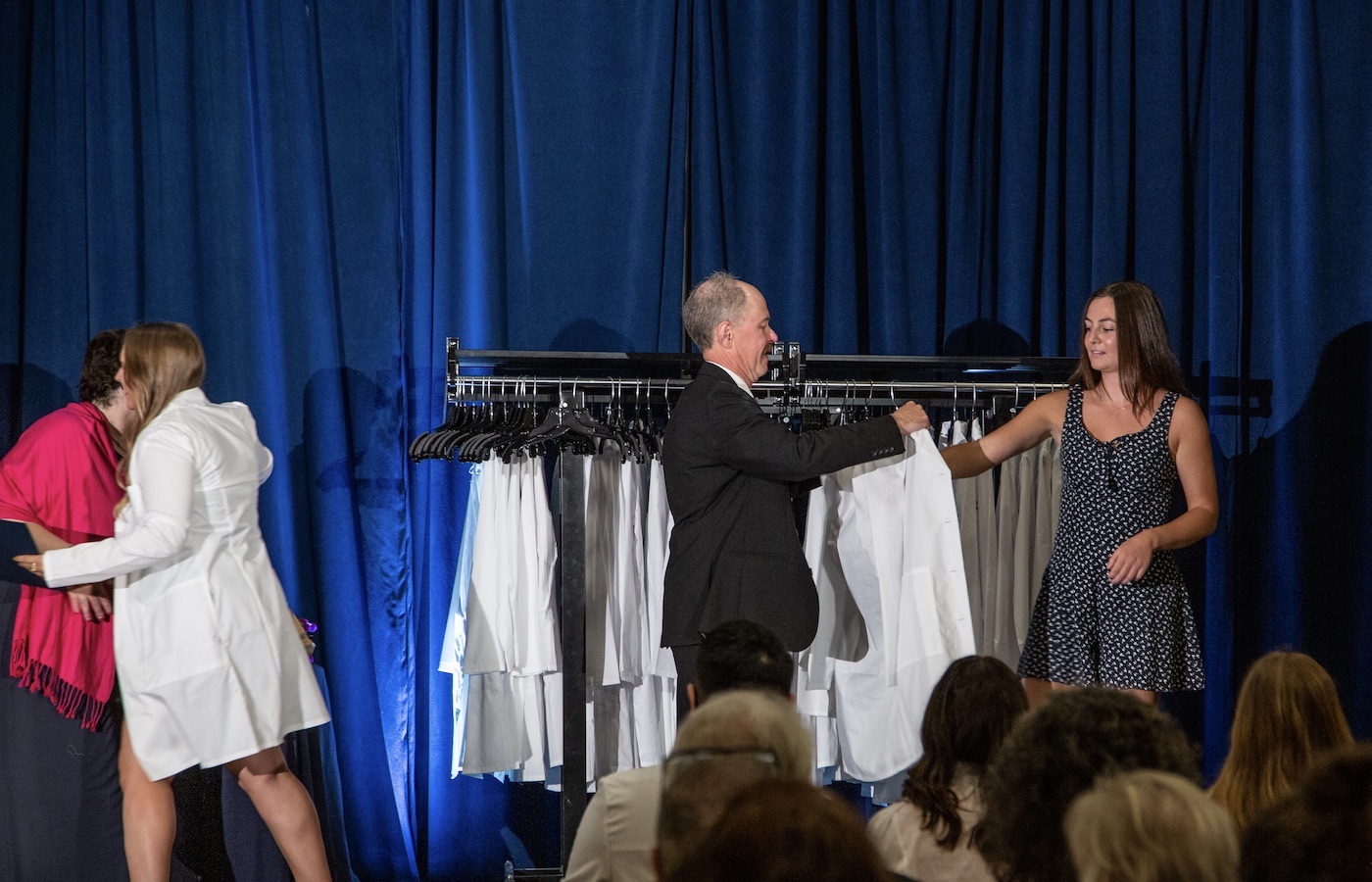 Physician assistant student receiving white coat at completion ceremony