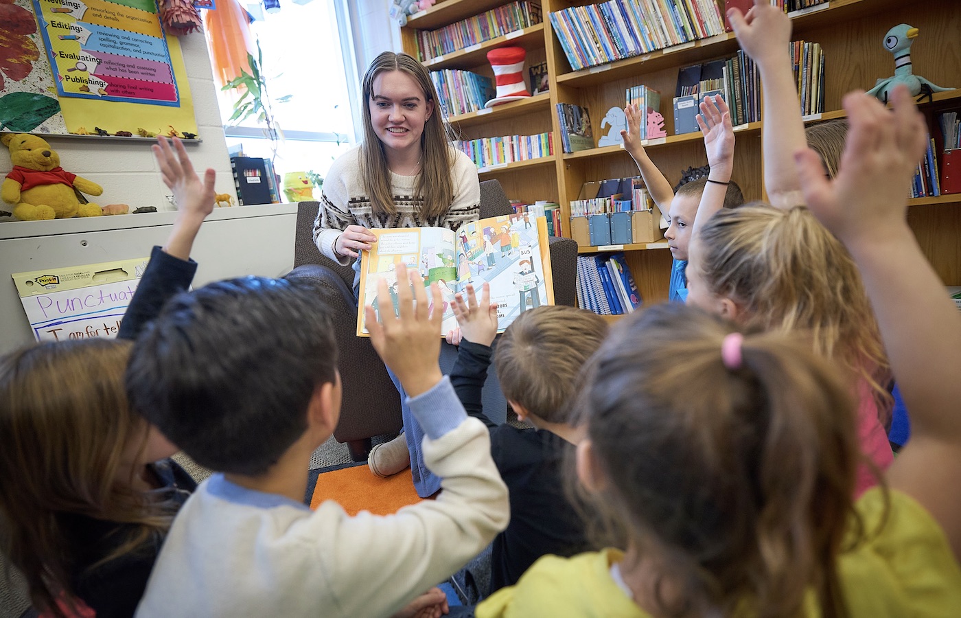 Student teacher reading to elementary school students