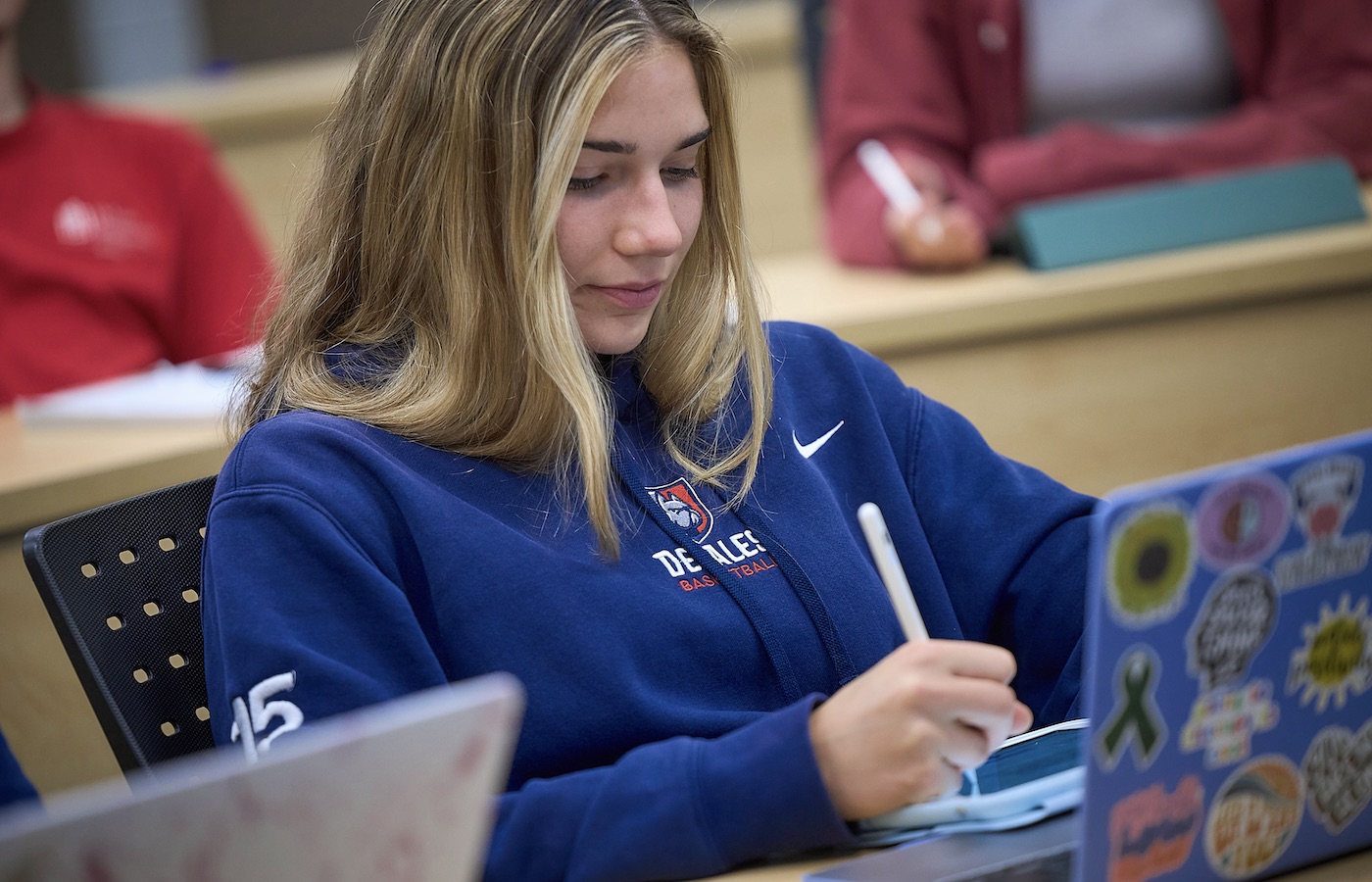 Student sitting in a classroom with a laptop computer